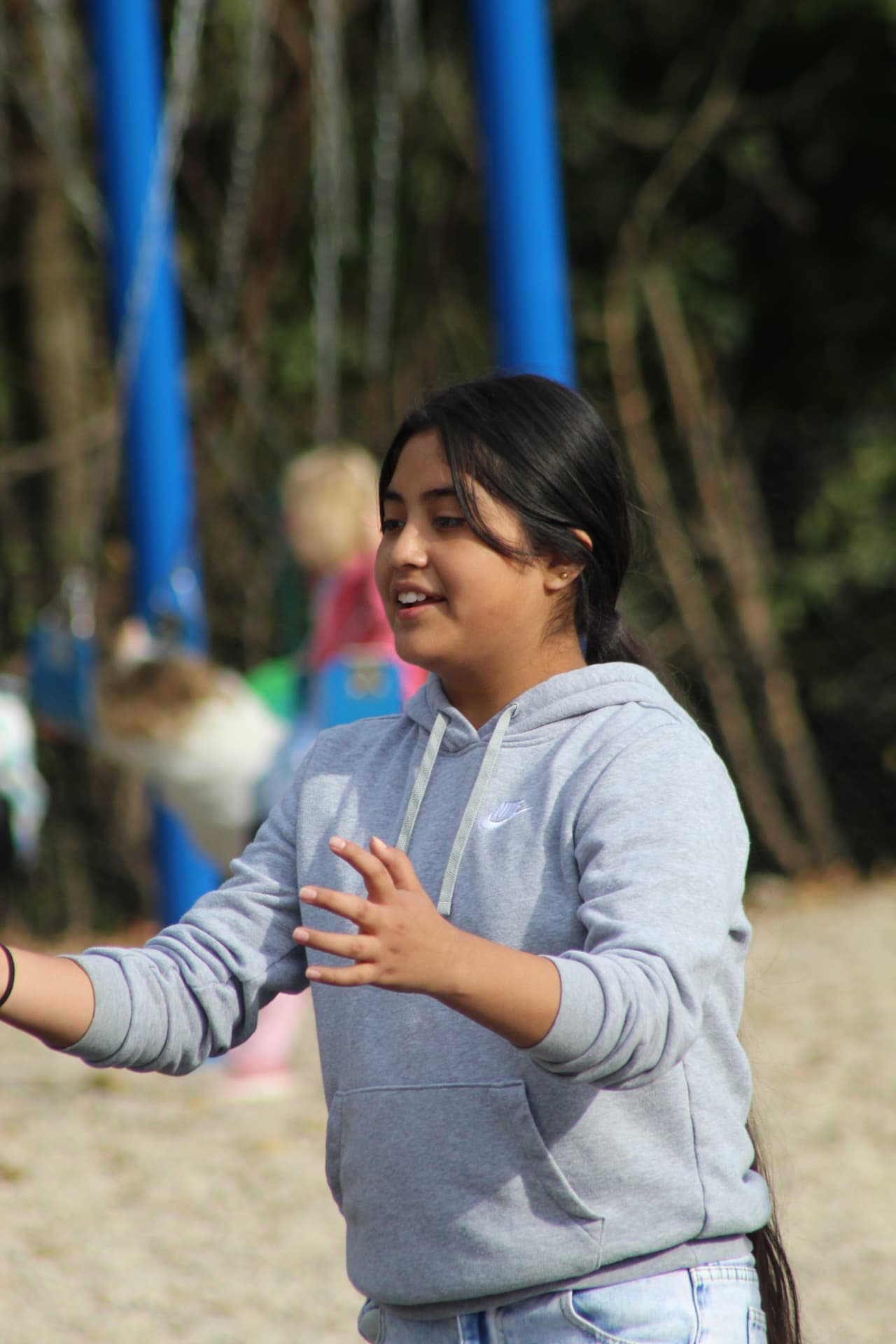 A smiling student enjoys time outdoors on the playground